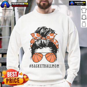 Pretty basketball mom with a messy bun, wearing sunshades and a sweatshirt, proudly supporting her child on the court.