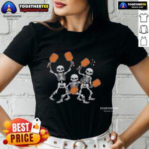 Top spooky skeletons play pickleball in Halloween-themed ladies tee, perfect for festive sports enthusiasts.