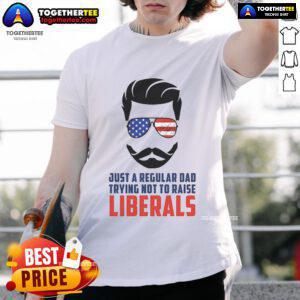 Top Just A Regular Dad Trying Not To Raise Liberals T-Shirt design featuring bold text for humorous parenting.