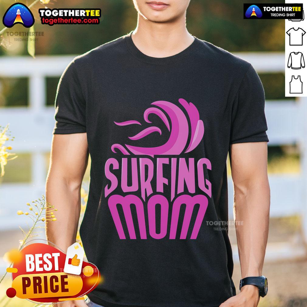 Surfing mom wearing a fun 'Top Surfing Mom' T-shirt, showcasing her love for surfing and motherhood on the beach.