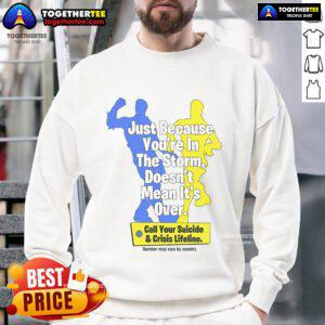 Alt Text: Official sweatshirt featuring 'Just Because You're In The Storm Doesn't Mean It's Over' design, promoting suicide crisis lifeline.