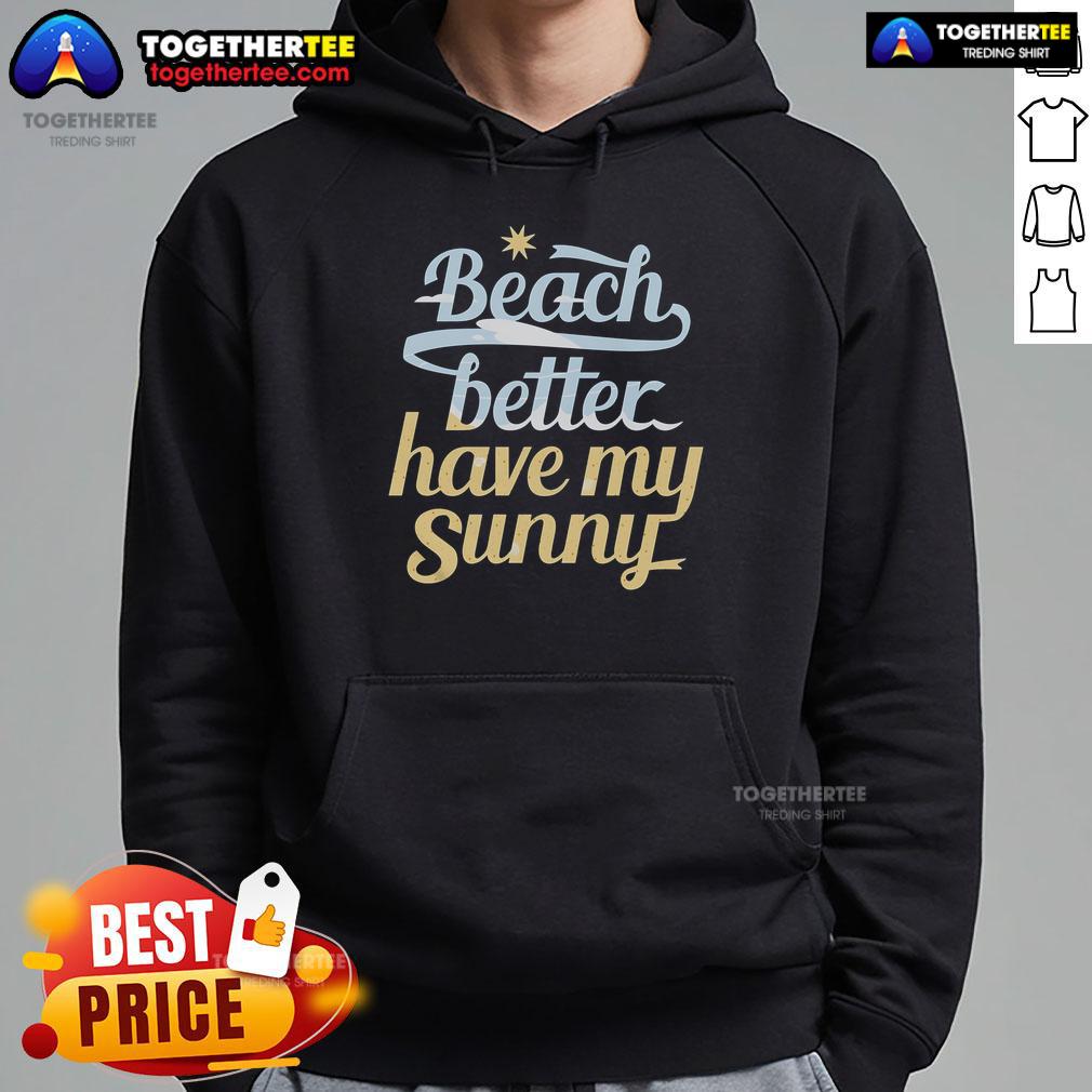 Person wearing a sunny hoodie at a pretty beach, enjoying the warm weather and vibrant ocean views.