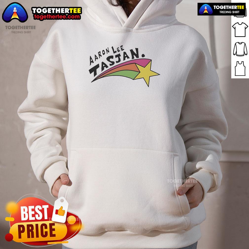 Happy Aaron Lee Tasjan wearing a colorful rainbow star hoodie, showcasing vibrant style and joyful expression.