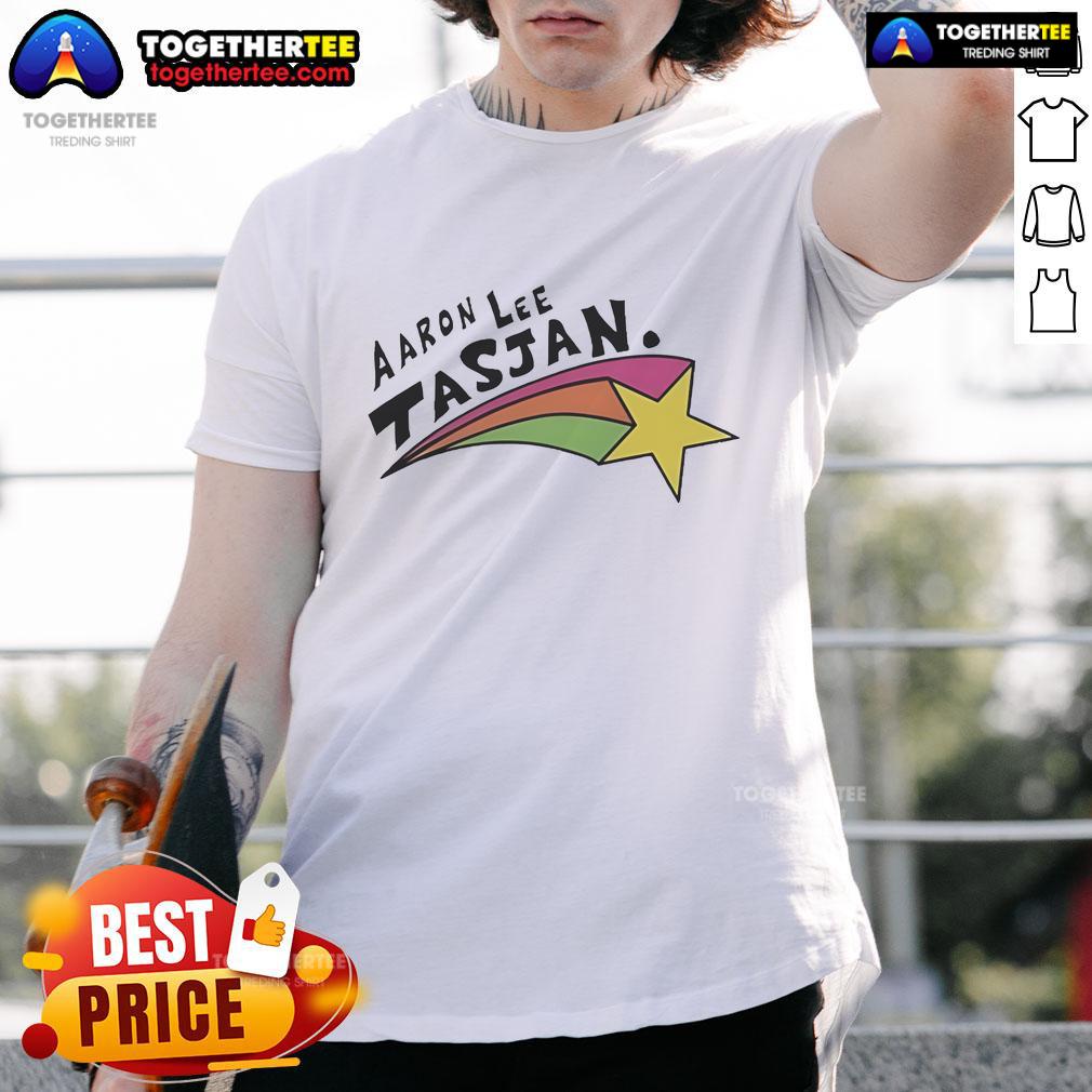 Alt Text: Happy Aaron Lee Tasjan wearing a colorful rainbow star t-shirt, showcasing vibrant design and joyful expression.