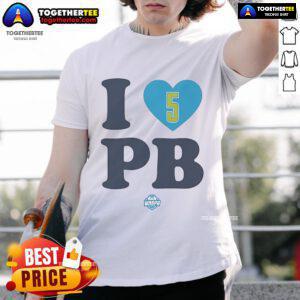 Happy Paige Bueckers wearing a 'I Love Pb' Dallas Wings T-shirt, showcasing her support for the WNBA team.