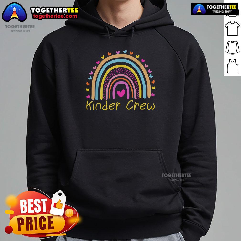 Alt Text: Kindergarten teacher wearing Nice Kinder Crew rainbow heart hoodie, smiling with kids in a colorful classroom setting.