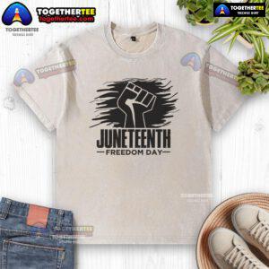 Alt Text: Official Juneteenth Freedom Day fist design on a washed t-shirt celebrating African American history and culture.