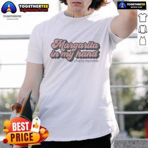 Premium Charly Reynolds Margarita T-shirt featuring a vibrant graphic, held in hand against a sunny outdoor backdrop.