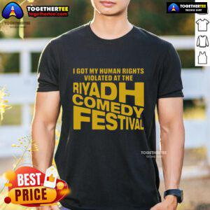 Alt Text: T-shirt featuring 'Good I Got My Human Rights Violated At The Riyadh Comedy Festival' slogan, highlighting human rights issues.