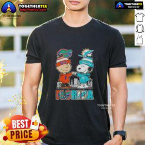 Alt Text: Cute Charlie Brown and Snoopy T-shirt featuring Florida Gators and Miami Dolphins skyline design.