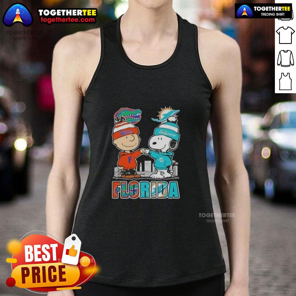 Cute Charlie Brown and Snoopy wearing Florida Gators and Miami Dolphins tank top against a vibrant skyline.