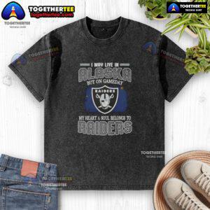 Good I May Live In Alaska But On Gameday My Heart And Soul Belongs To Raiders washed t-shirt displayed on a hanger.
