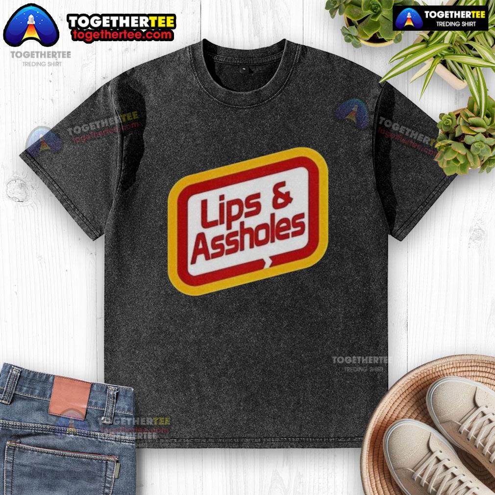 Good Lips and Assholes Washed T-Shirt displayed on a hanger, showcasing its unique graphic design and soft fabric.