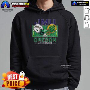 Alt Text: Happy fan wearing a James Madison Dukes hoodie at Autzen Field, cheering for the NCAA CFP 2025 against Oregon Ducks.