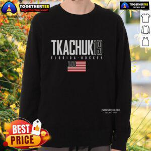 Matthew Tkachuk wearing a Florida Panthers sweatshirt featuring the USA flag, showcasing team pride and style.