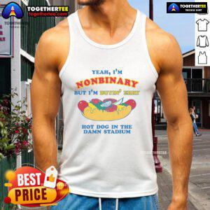 Nonbinary person in a stadium tank top happily buying hot dogs, showcasing pride and fun in their identity.