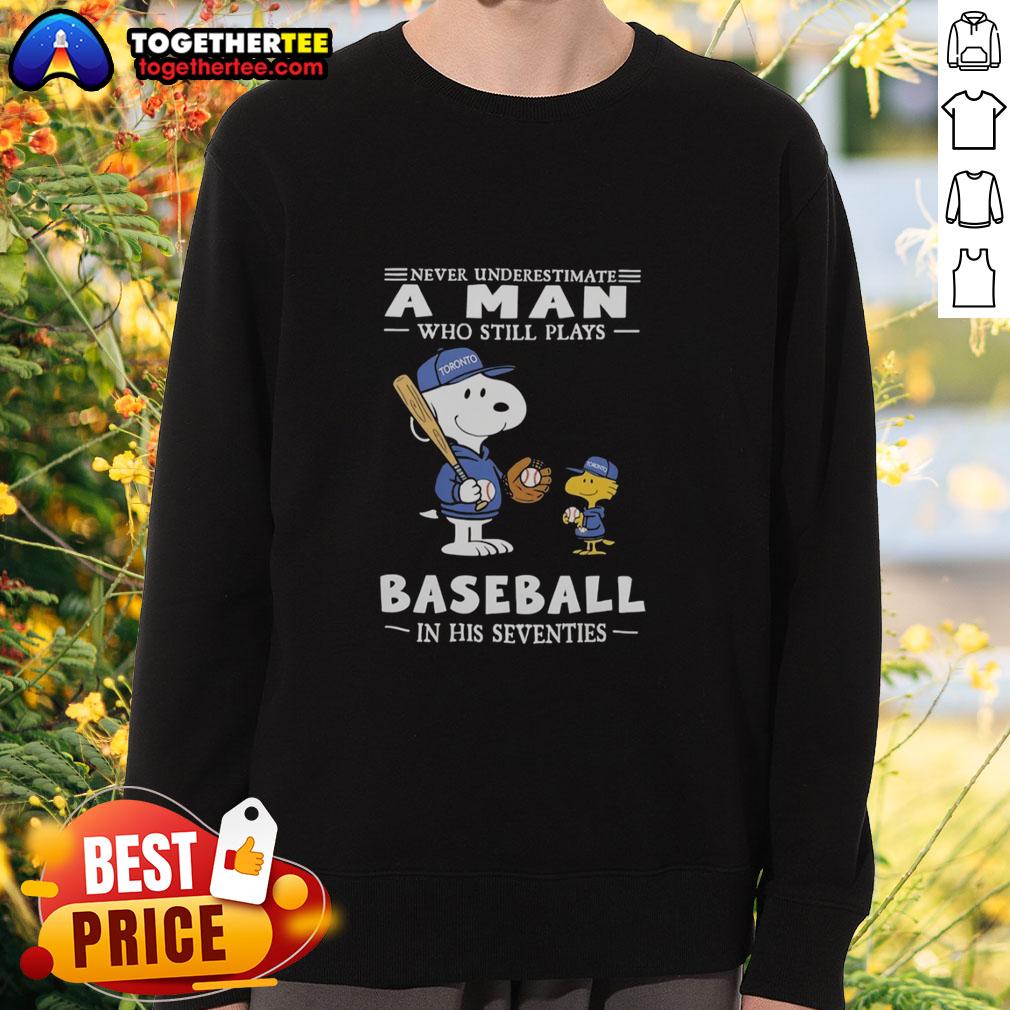 Nice The Peanuts X Toronto Blue Jays sweatshirt featuring 'Never Underestimate A Man Who Still Plays Baseball In His Seventies' design.