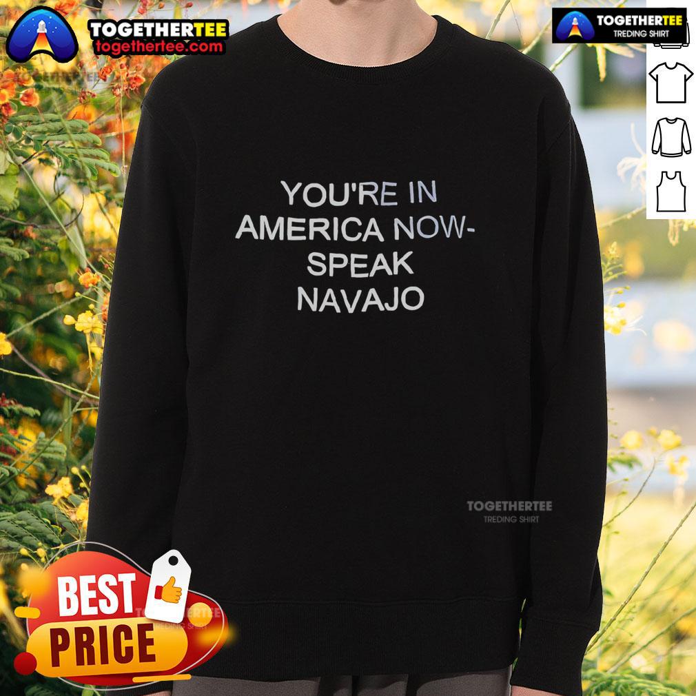 Official 'Youre In America Now, Speak Navajo' sweatshirt featuring bold text design for cultural pride and awareness.