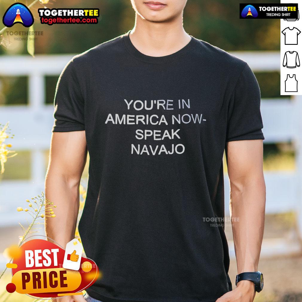 Alt Text: Official You're In America Now Speak Navajo T-Shirt featuring bold text and traditional Navajo design elements.