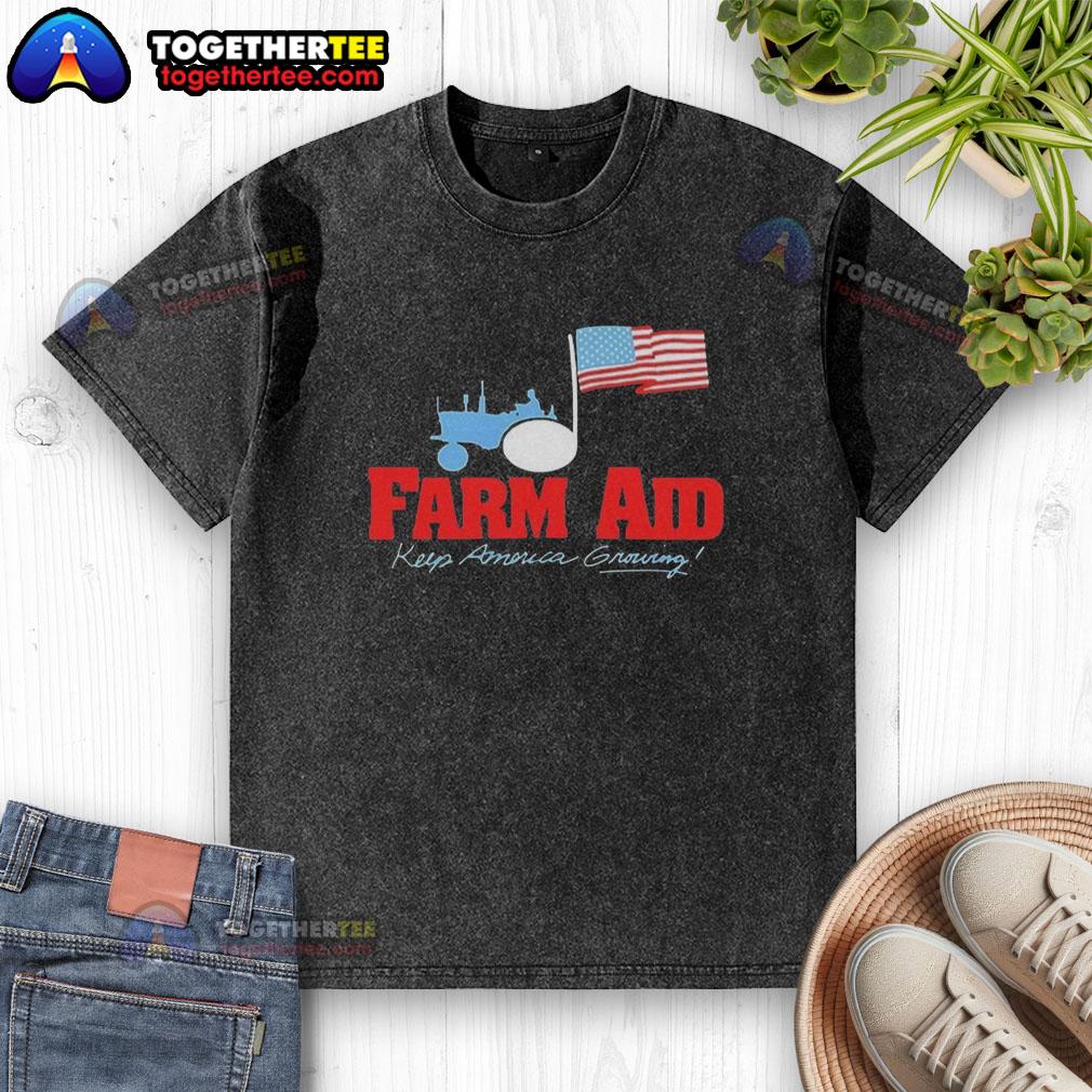 Alt Text: Premium Farm Aid Keep America Growing logo featuring a tractor and American flag on a washed t-shirt.